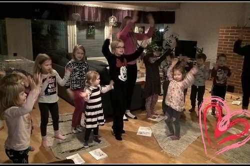 Joukko lapsia kädet ylhäällä leikkimässä laulun tahtiin musapyhiksessä.