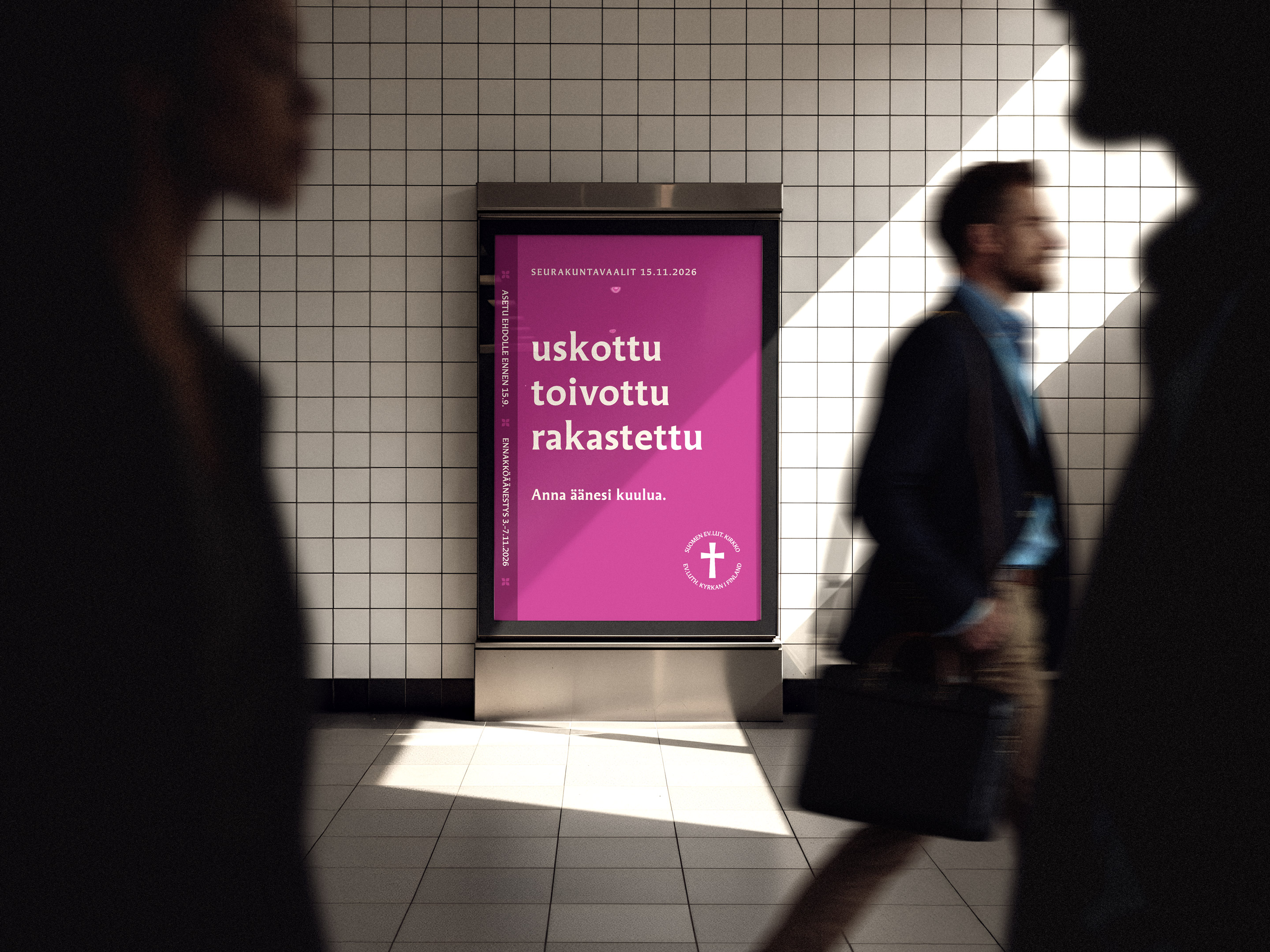 Ihmisiä kävelemässä kaupungilla, taustalla vaalimainosständi.